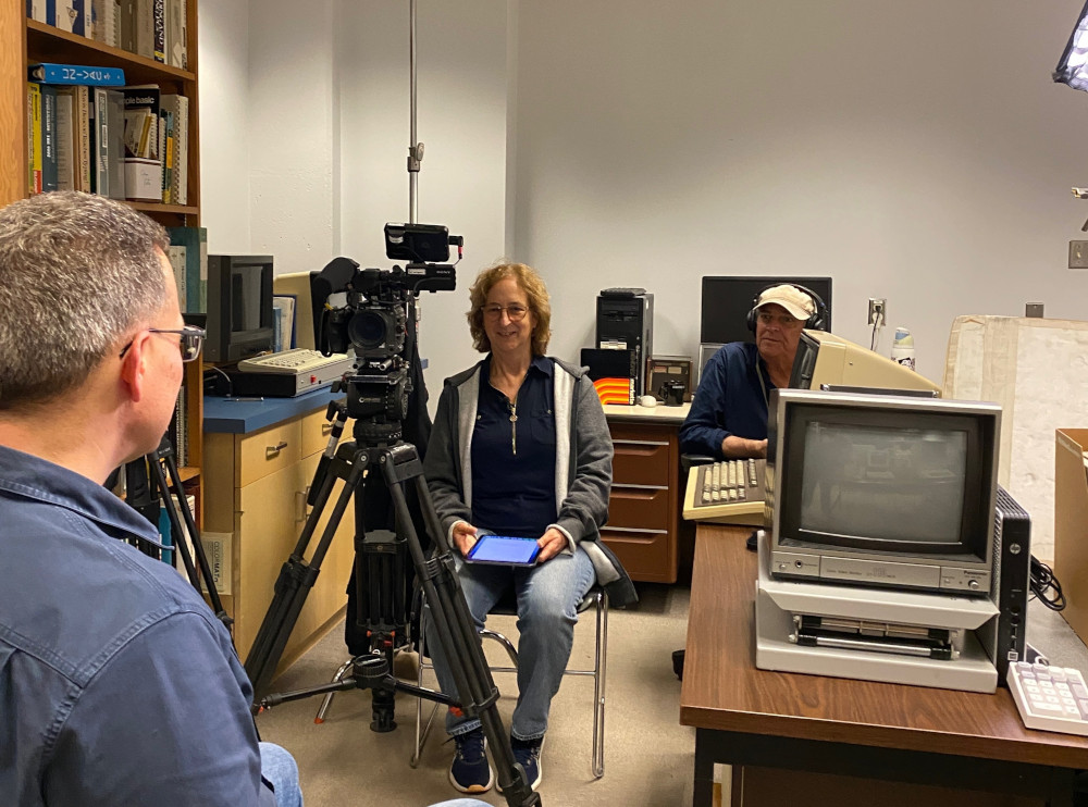 Director and sound engineer in the lab with camera equipment. Lab manager is seen from the rear
