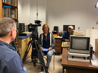 Director and sound engineer in the lab with camera equipment. Lab manager is seen from the rear