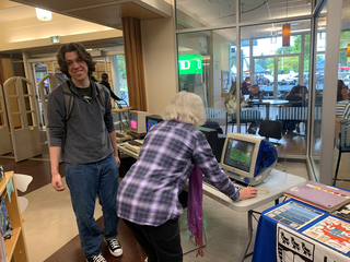 Two exhibition visitors interacting with the computers on display